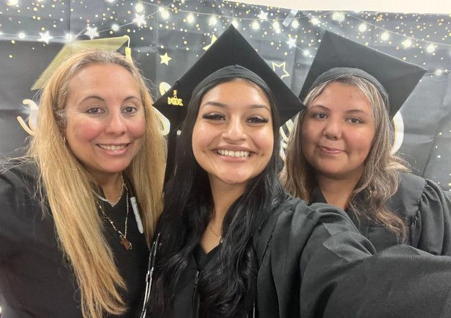 Graduates posing with congratulatory sign